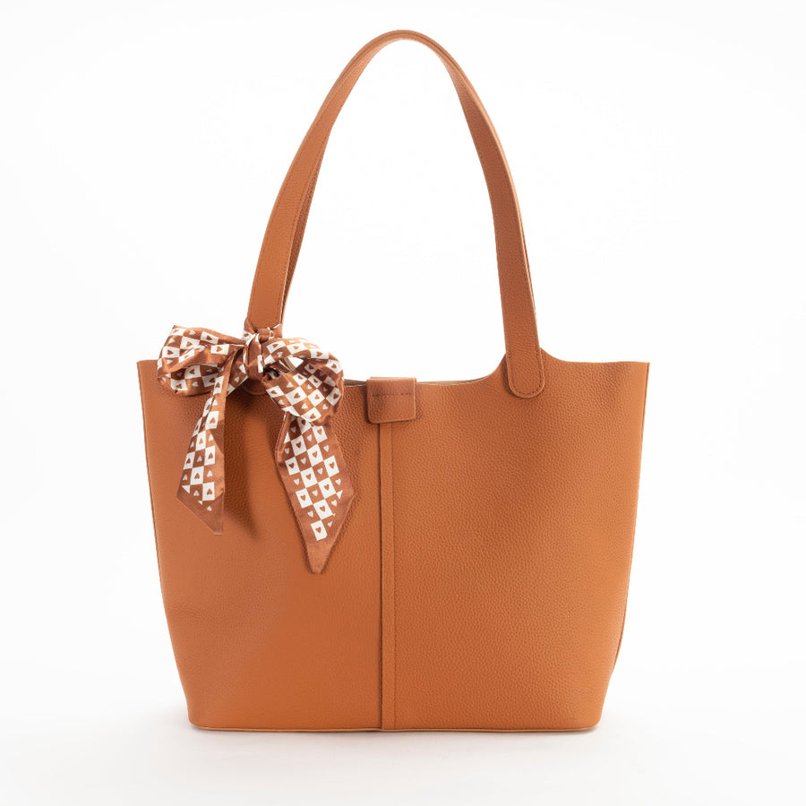 A brown leather tote bag with a detachable scarf in a zippered compartment, displayed against a plain background.
