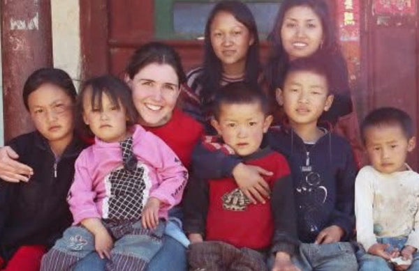 Carmen Sivunigunta with a group of children in an outdoor setting