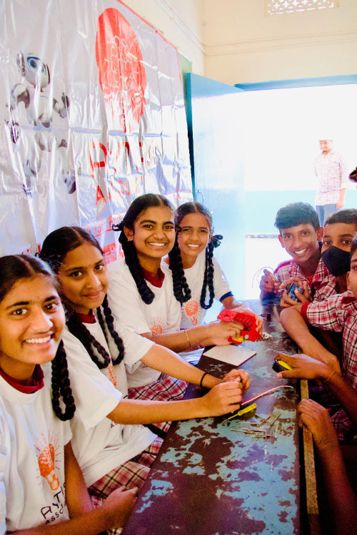 Group of students sitting around a table in a classroom setting
